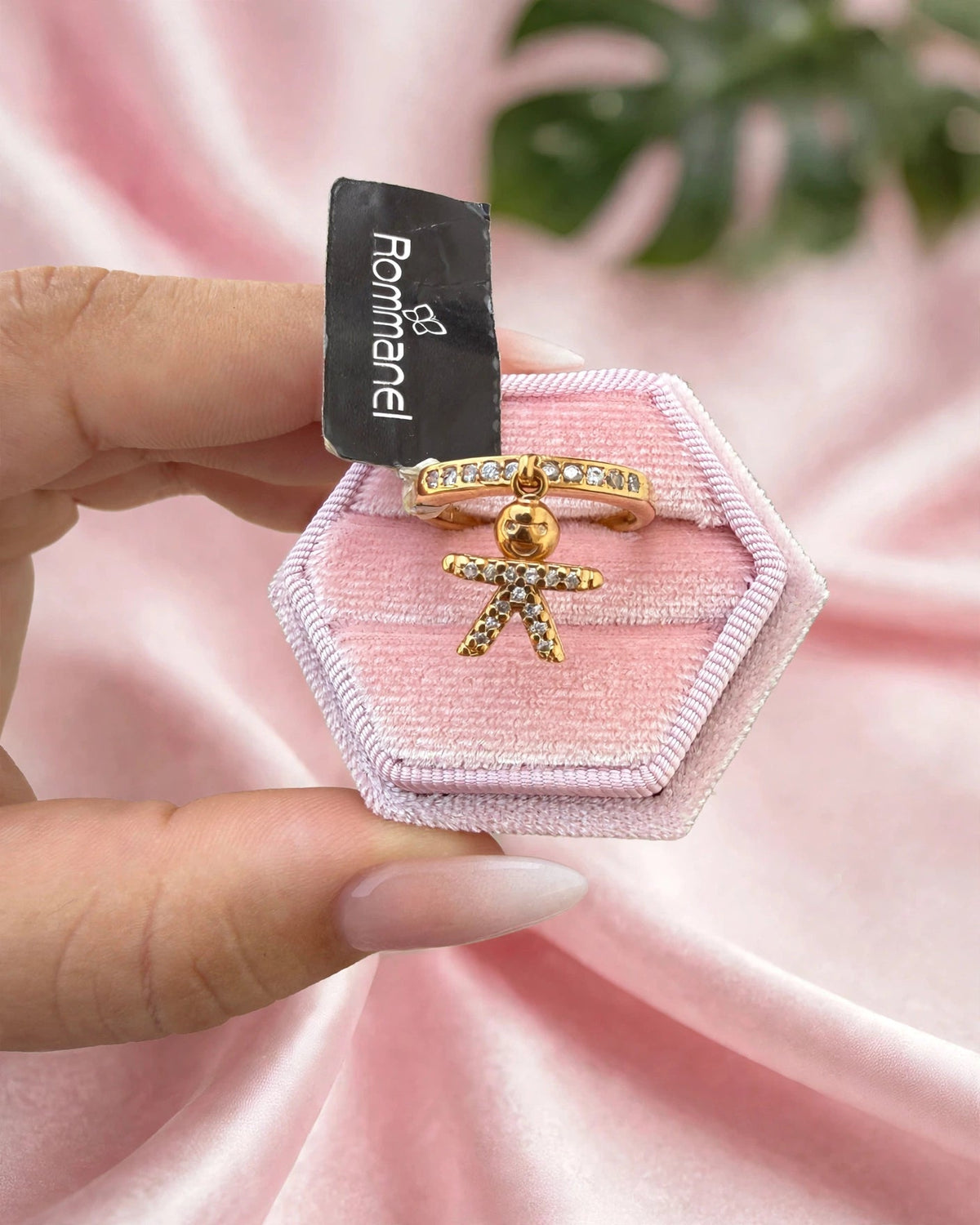 Anel Aparador Zircónias com Pingente Menino Rommanel - detalhe do pingente menino na caixa rosa fundo cetim rosa