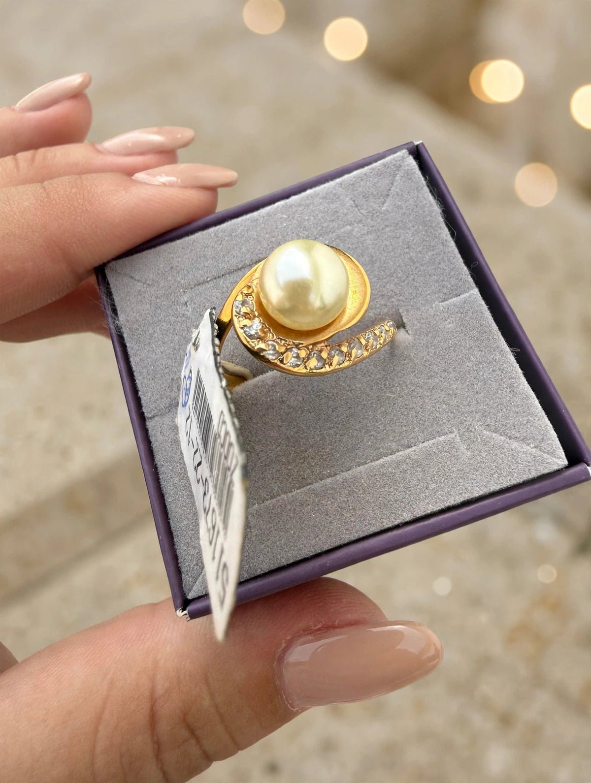 Anel Pérola Espiral Zircónias Rommanel - na caixa roxa veludo com etiqueta Rommanel fundo bokeh dourado