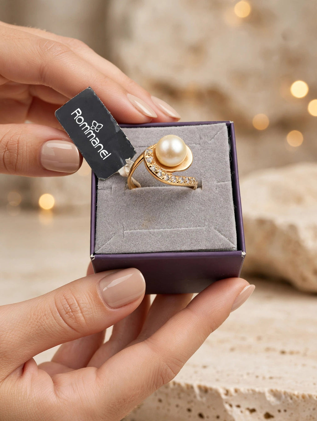 Anel Pérola Espiral Zircónias Rommanel - na caixa roxa veludo vista de cima fundo bokeh dourado